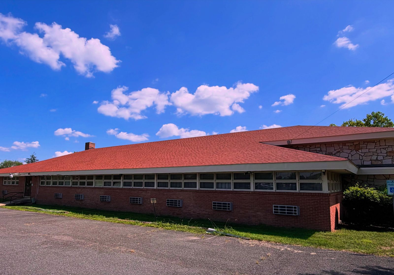 The full length of the church hall seen from the parking lot, with its new terra cotta roof