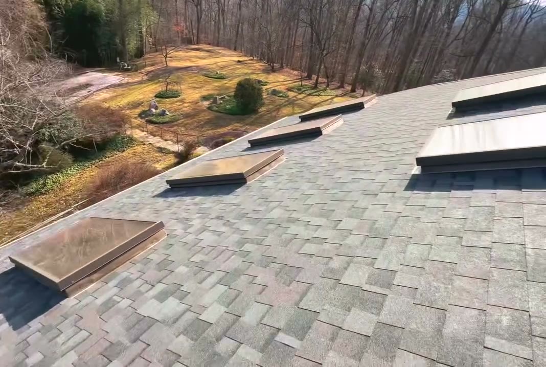 Finished shingle roof with a row of skylights
